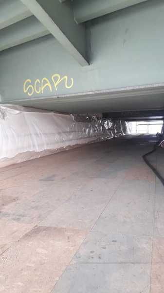 Plane unter dem Überbau als Staubschutz für die Arbeiten am Bauwerk, der Durchgang darunter bleibt begehbar.